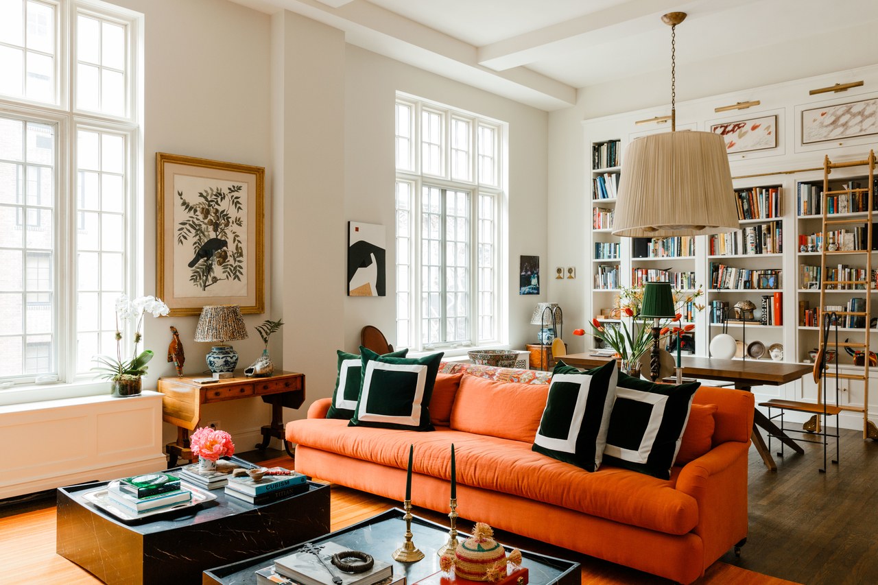 orange sofa in a white loft living room space | home of james hirschfeld via arch digest