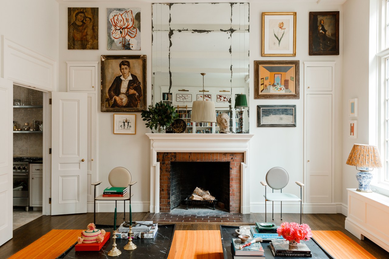 a lofted gallery wall surrounds the fireplace | james hirschfeld home via arch digest