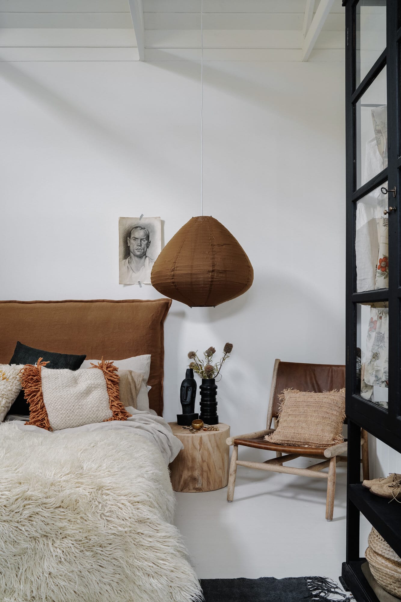 rust linen headboard and layered textiles in this organic modern bedroom