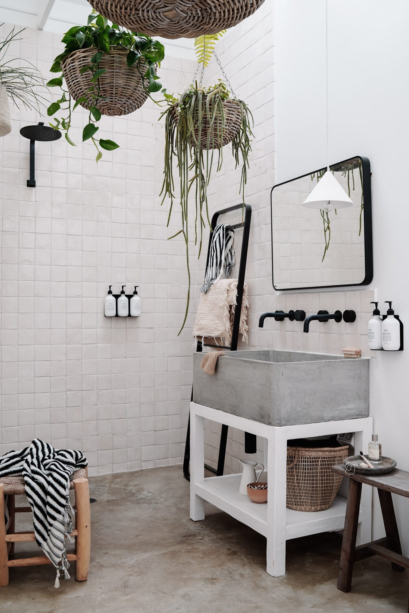 concrete and natural tile with hanging planter baskets in a styled rental cottage