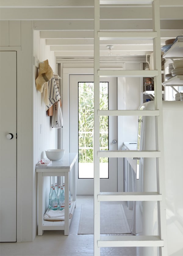 a ladder leads up to the bedrooom in this miniature whitewashed beach house
