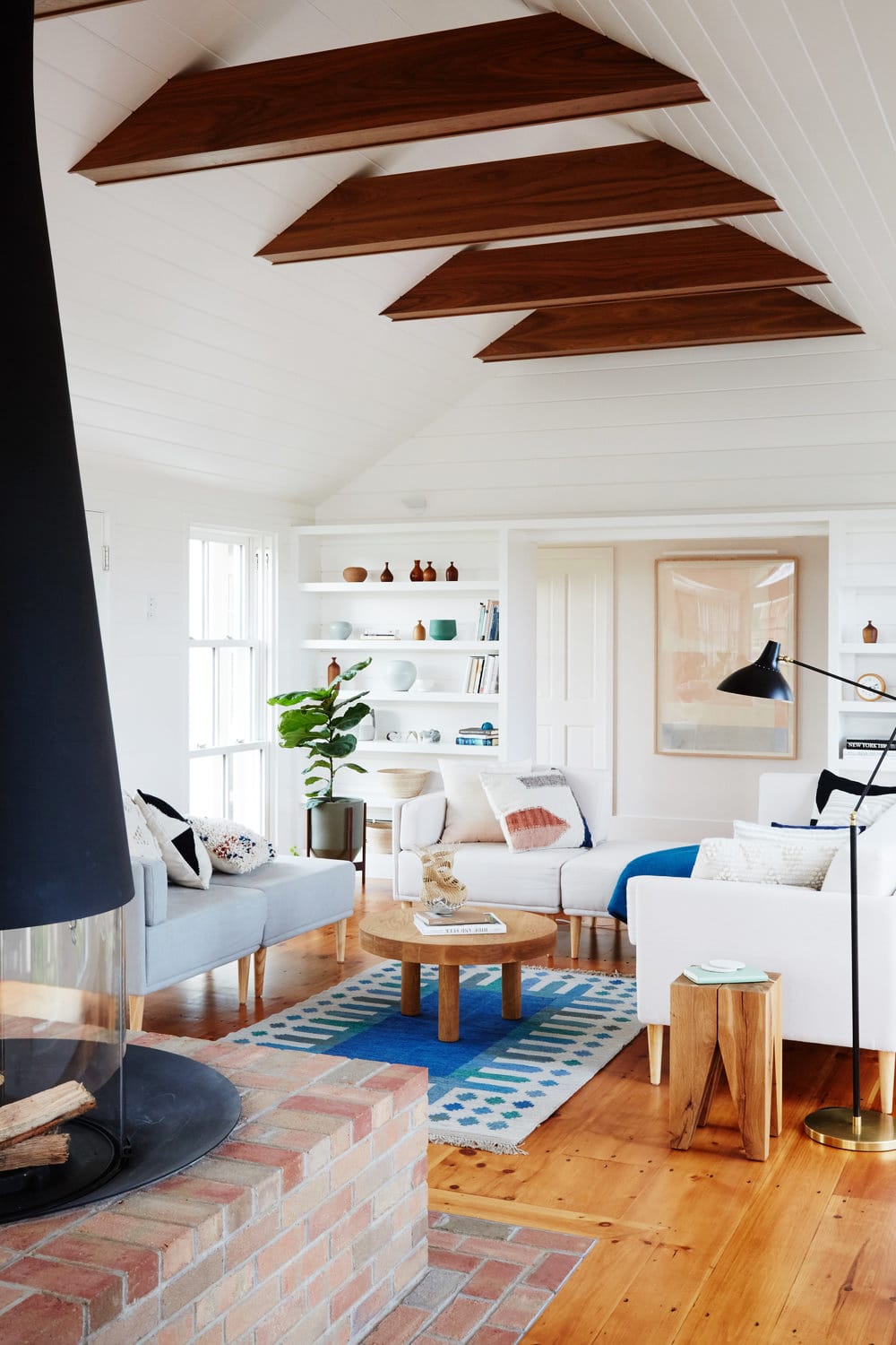 a mid-century style fireplace contrasts the small seating area in this martha's vineyard home | modern shaker beach house tour on coco kelley