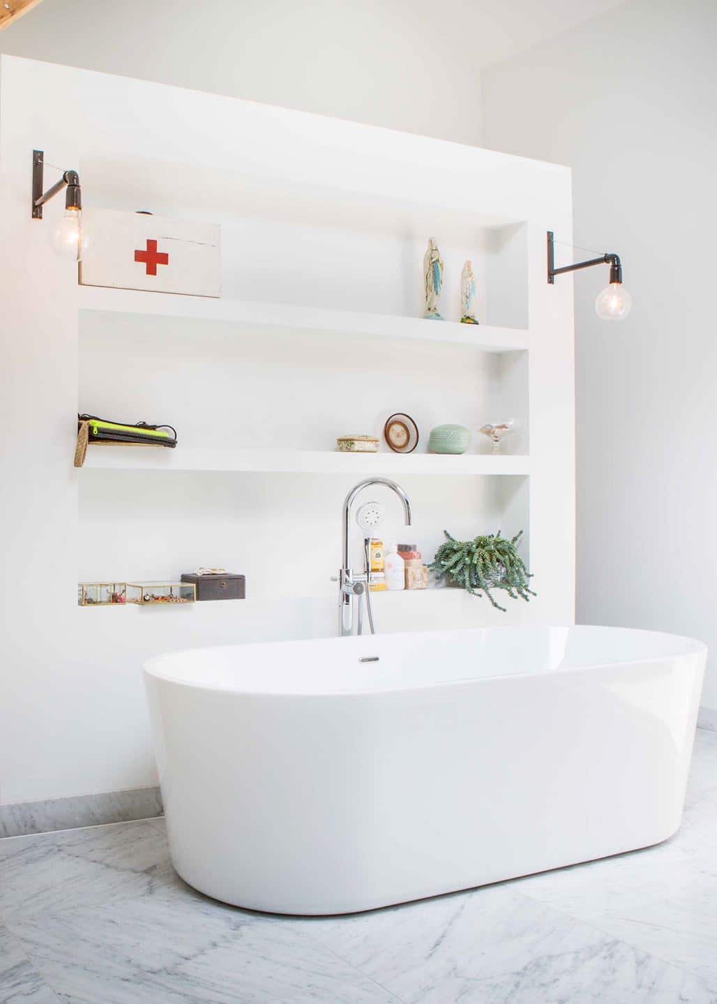 a spacious bathroom with free standing modern tub and open shelving | house tour on coco kelley