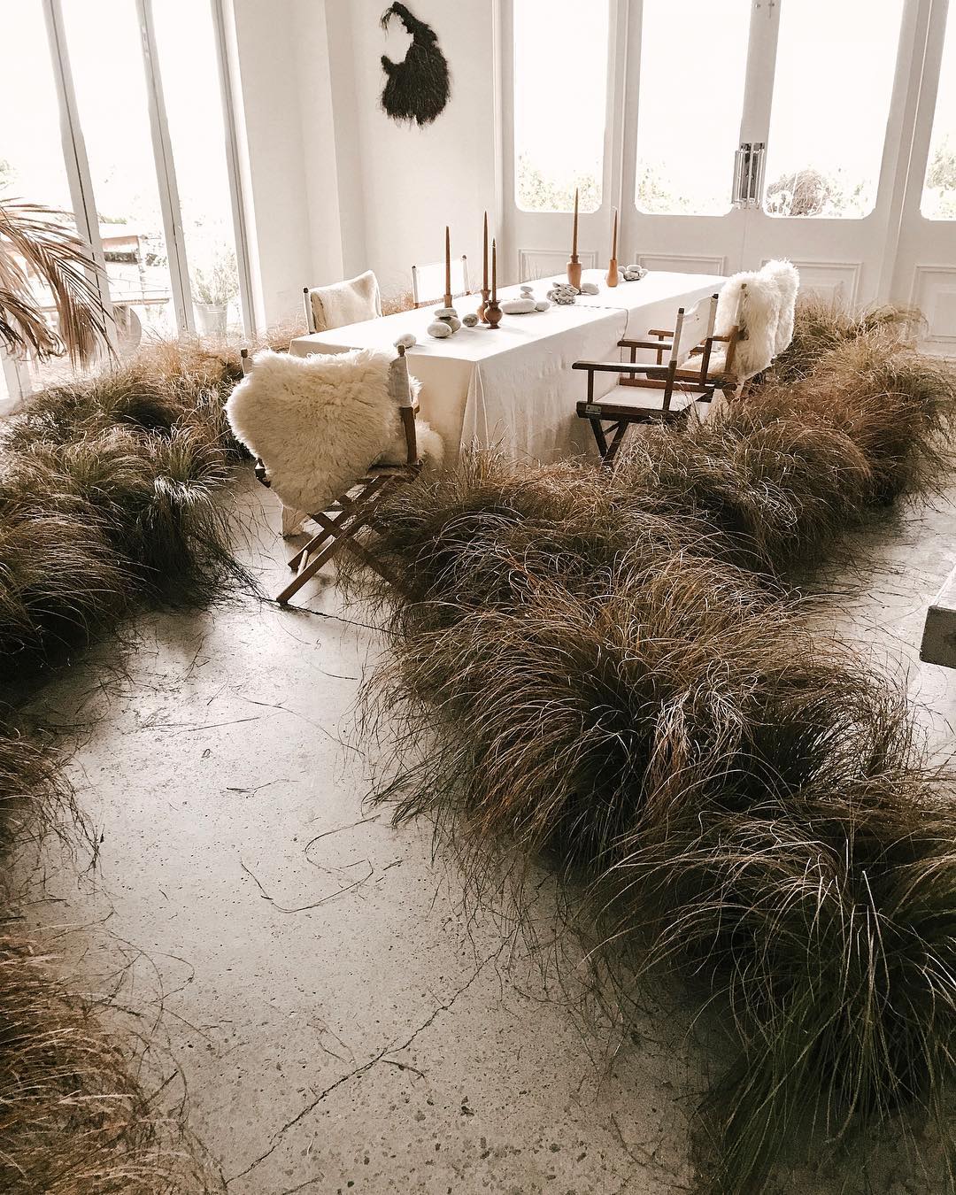 an aisle made from grasses leads to a simple table | thanksgiving table setting ideas on coco kelley