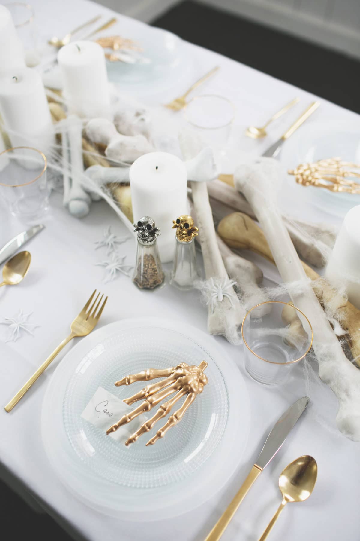 an all white ghostly halloween tabletop with bone and candle centerpiece runner | coco kelley