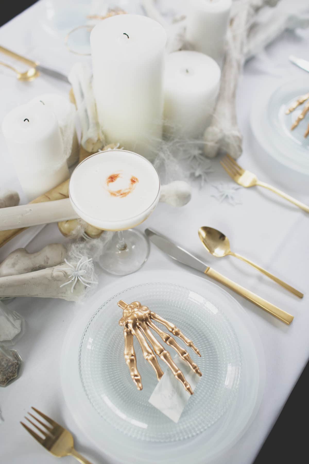 an all white ghostly halloween tabletop with bone and candle centerpiece runner | coco kelley