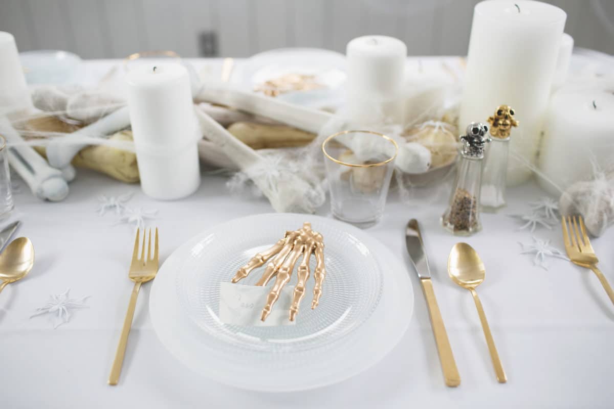 an all white ghostly halloween tabletop with bone and candle centerpiece runner | coco kelley