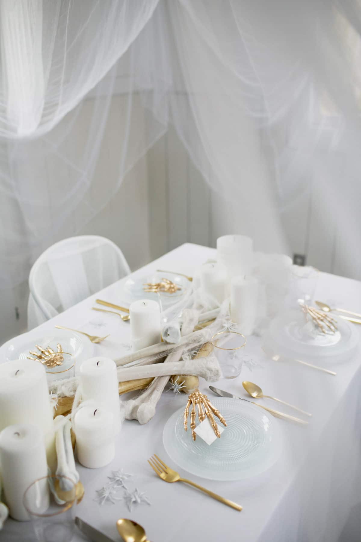 an all white ghostly halloween tabletop with bone and candle centerpiece runner | coco kelley