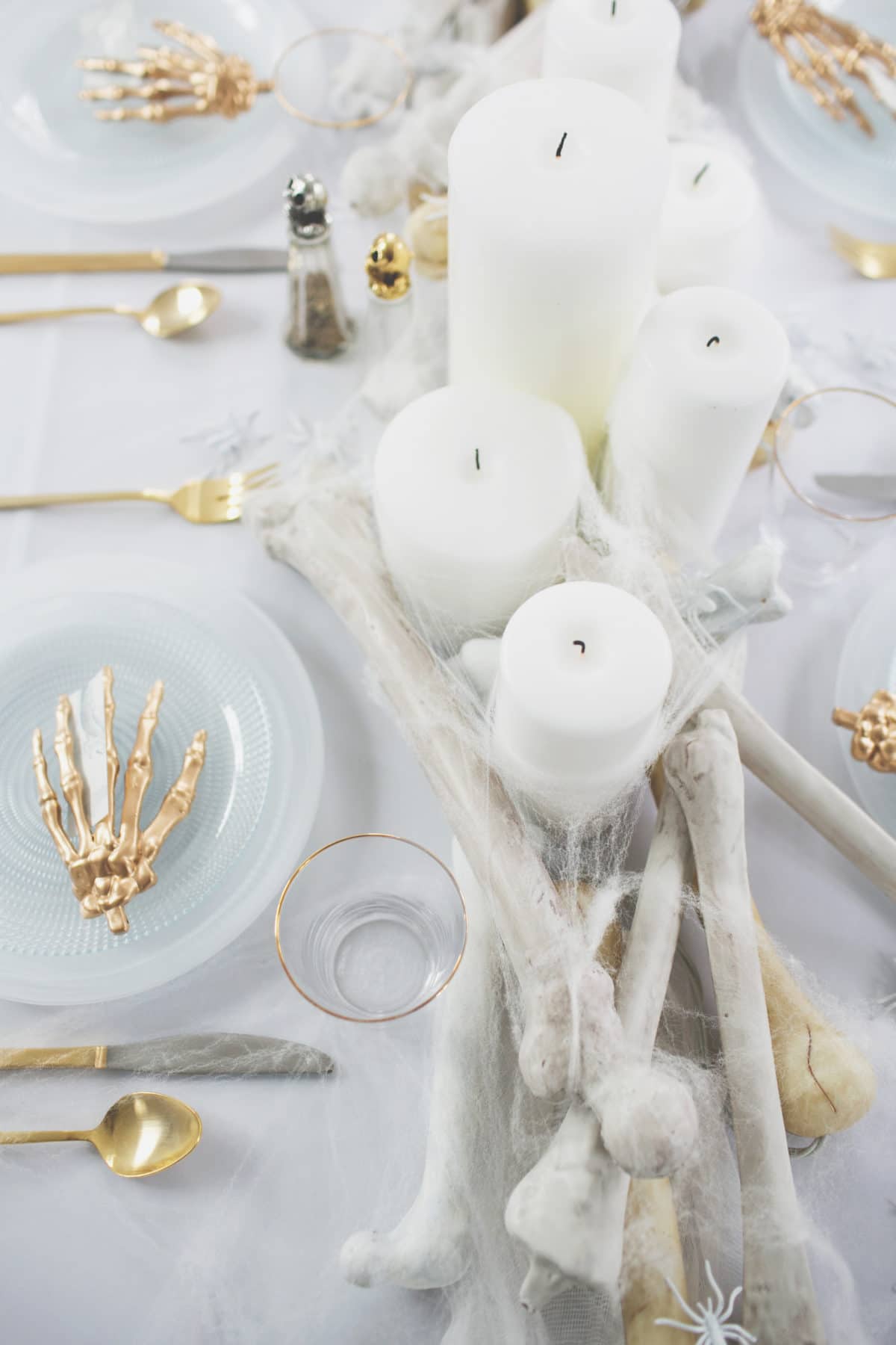 an all white ghostly halloween tabletop with bone and candle centerpiece runner | coco kelley