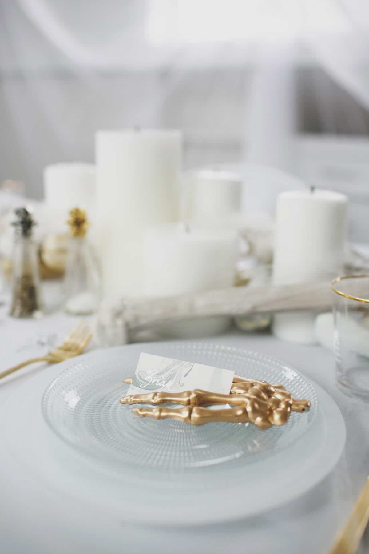 an all white ghostly halloween tabletop with bone and candle centerpiece runner | coco kelley