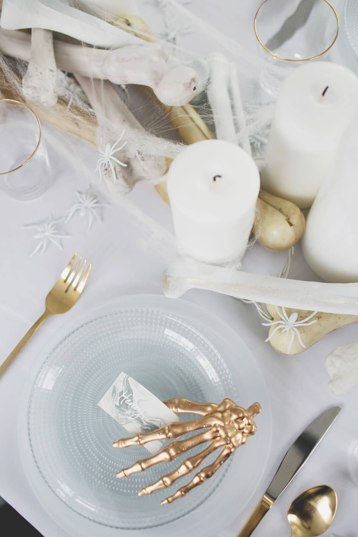 an all white ghostly halloween tabletop with bone and candle centerpiece runner | coco kelley