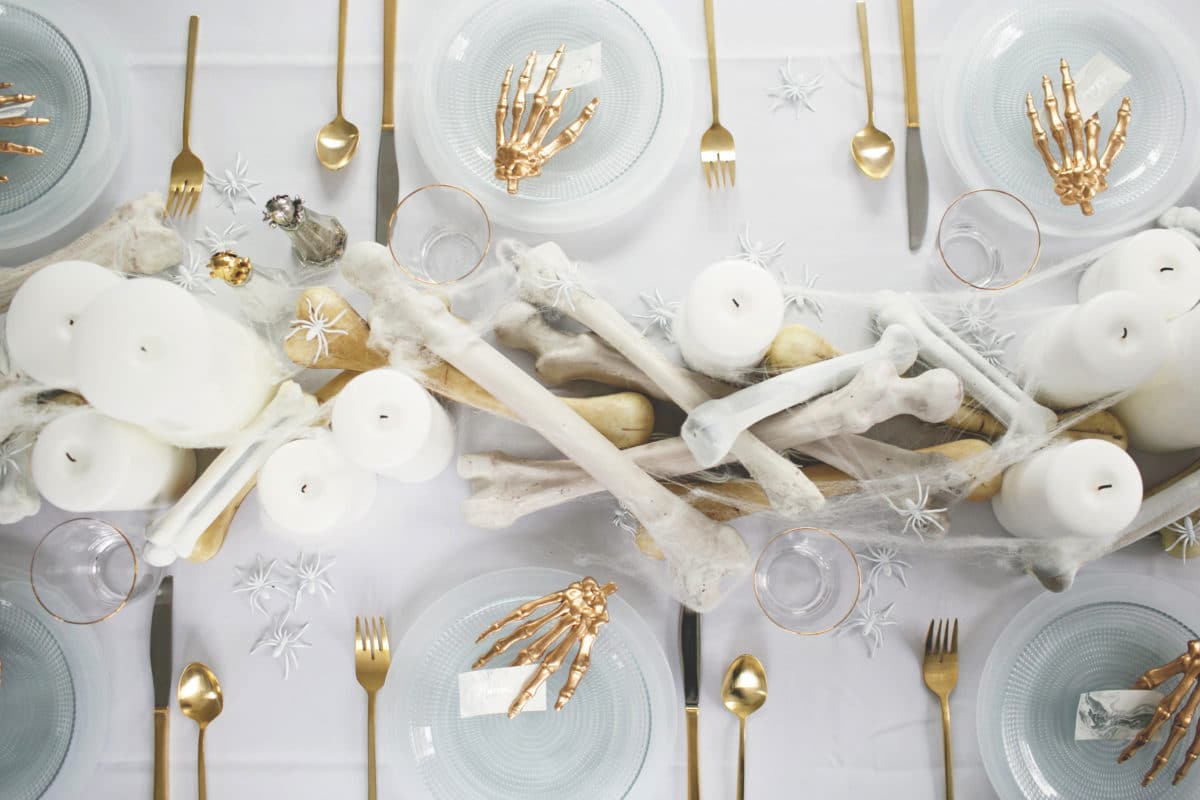 an all white ghostly halloween tabletop with bone and candle centerpiece runner | coco kelley
