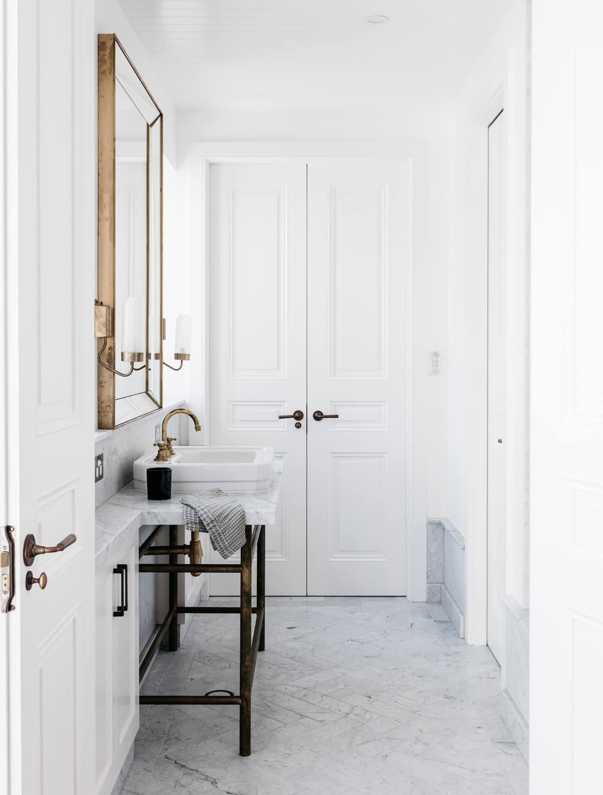 clean fresh bathroom in all white with small storage and marble floors | coco kelley