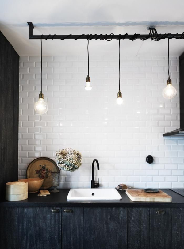 black and white kitchen with industrial fixtures + black faucet + dark wood cabinets