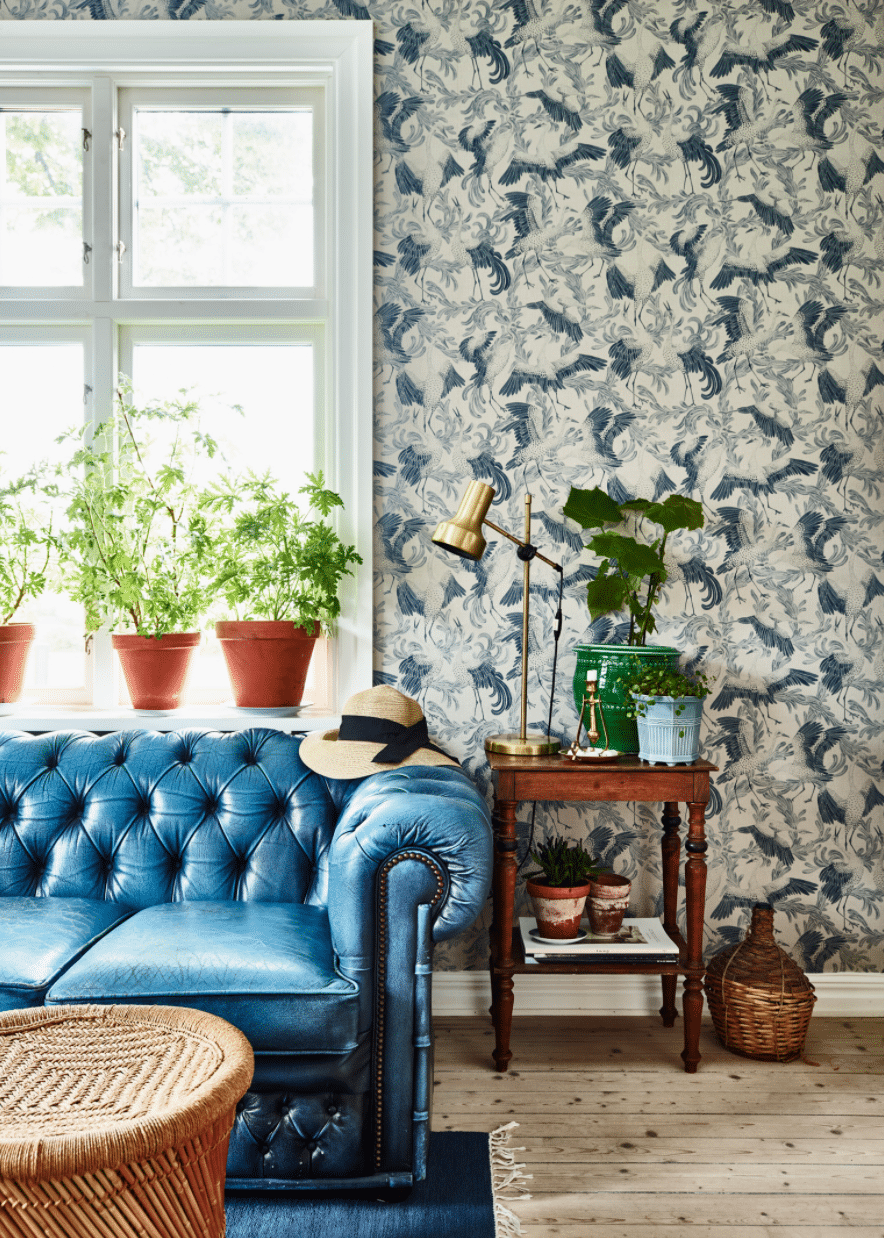 blue and white wallpaper with a blue leather tufted sofa in the living room | swedish house tour on coco kelley
