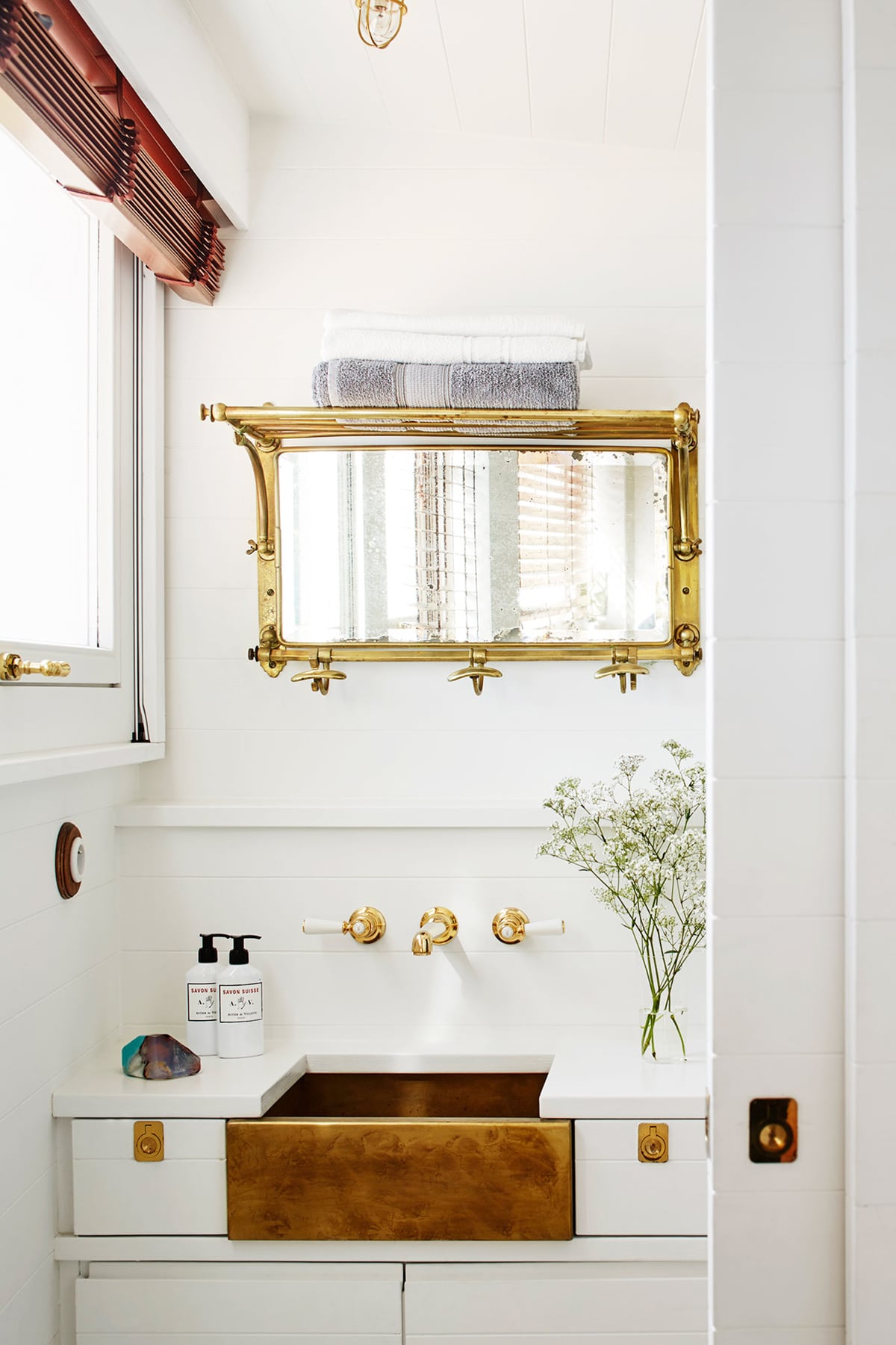 brass and white reign in the bathroom of this chic and tiny home on the italian riviera | house tour on coco kelley