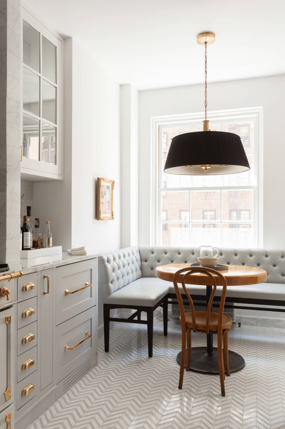 classic grey and white kitchen with brass hardware and black pendant in a gorgeous breakfast nook | via coco kelley