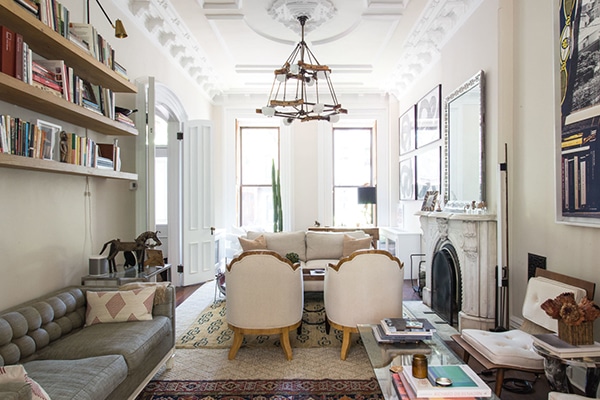 a long living room is divided into THREE spaces with layered rugs and lots of vintage furniture in neutrals | coco+kelley brooklyn brownstone home tour