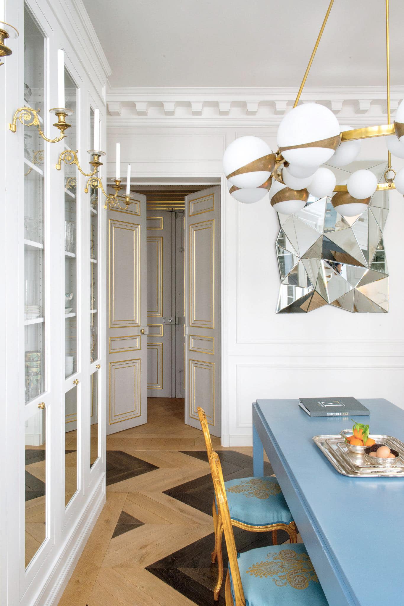 glamorous eclectic modern parisian kitchen with a blue island and brass accents | room of the week on coco kelley