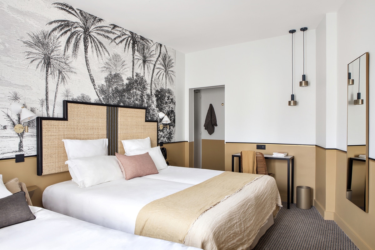 hotel doisy woven headboard and black and white tropical mural wallpaper | via coco kelley
