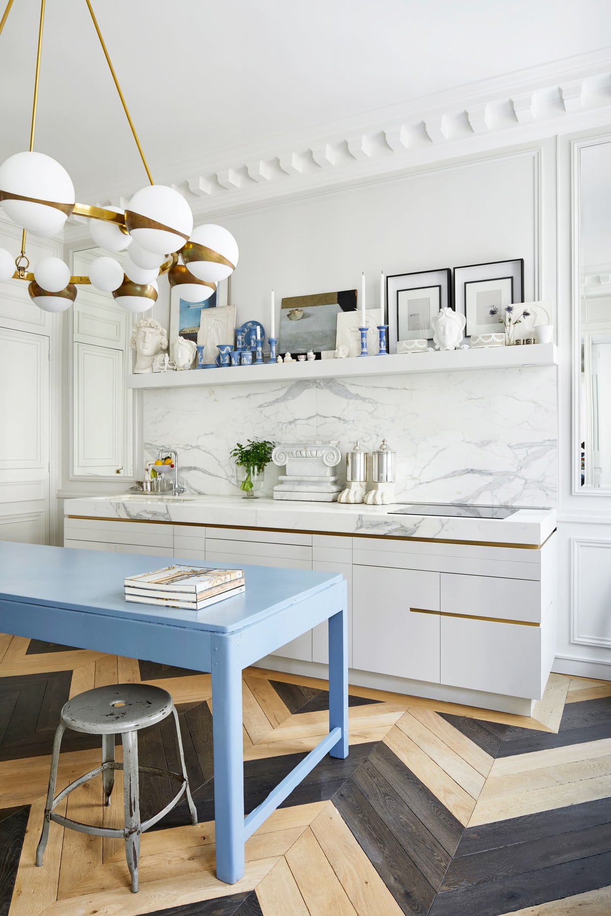 glamorous eclectic modern parisian kitchen with a blue island and brass accents | room of the week on coco kelley