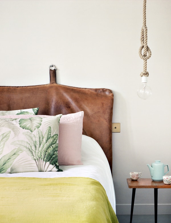 leather headboard with tropical colors and pillows in the bedroom - hotel henriette | coco kelley