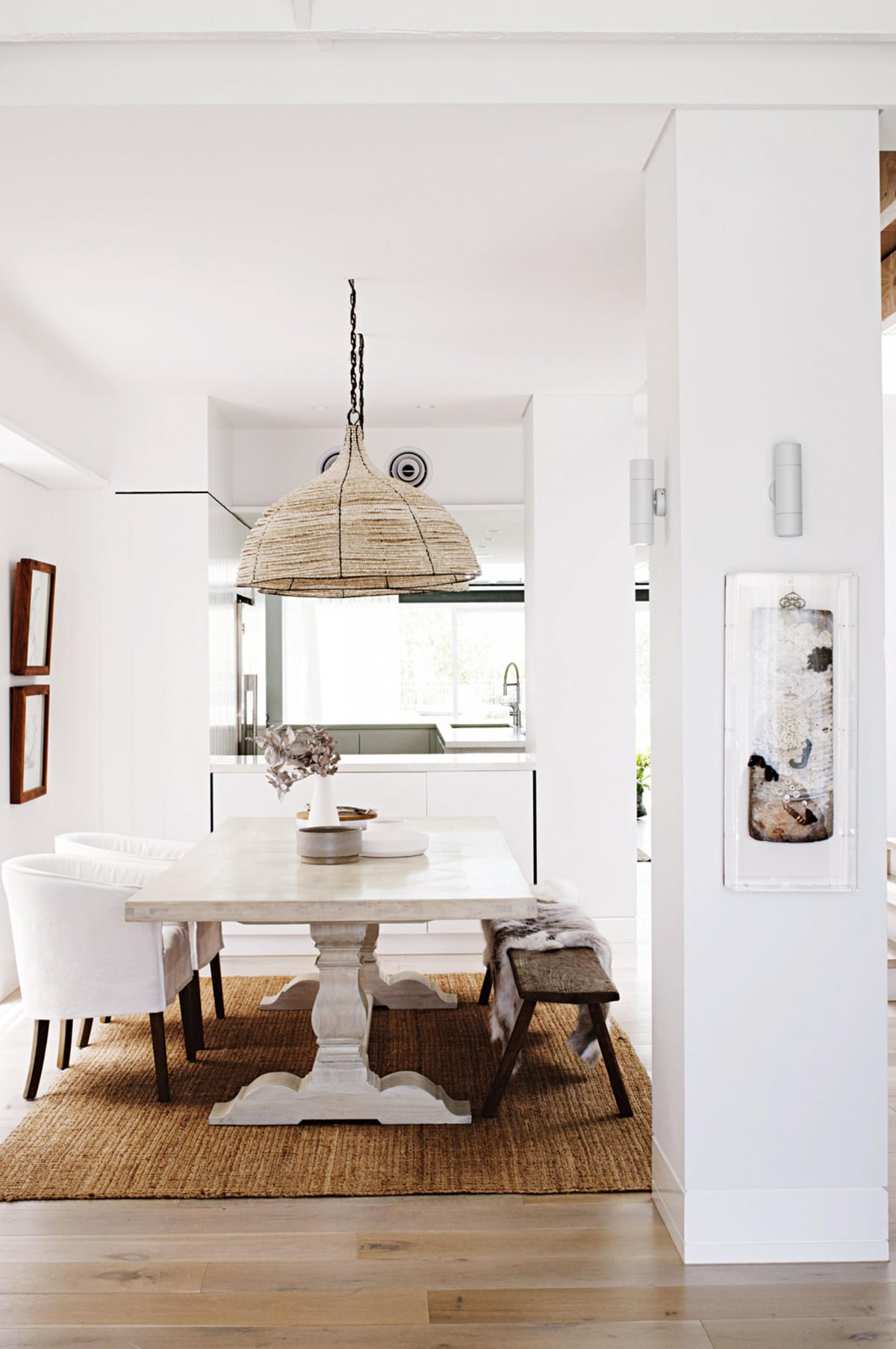lofty white dining room with library table and oversized African beaded pendants | room of the week on coco kelley