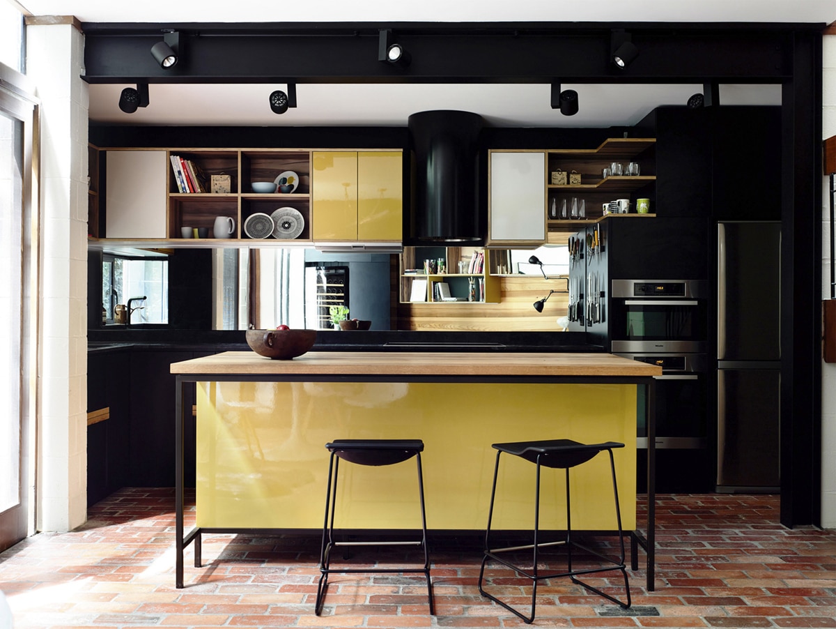 mod yellow kitchen island with terracotta brick tile floors | coco kelley
