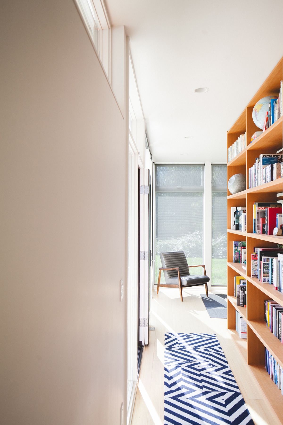 modern prefab home with built-in bookshelf hallway | emerald studio design coco kelley