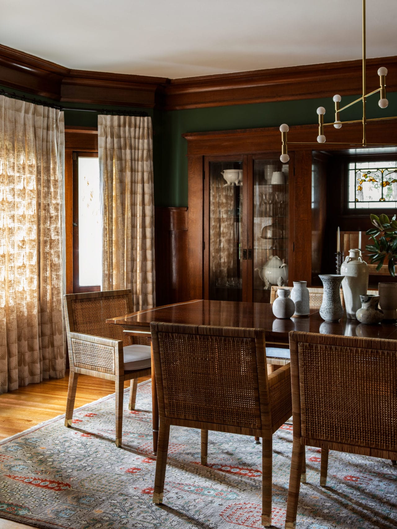 moody dark dining room with woven chairs dark wood and green walls | modern historic craftsman house tour jacey duprie
