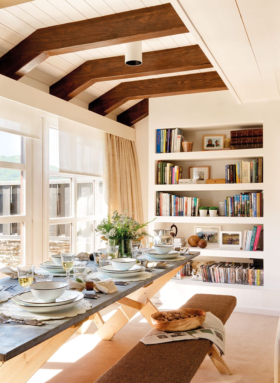 open concept living and dining room with tons of light and exposed beams