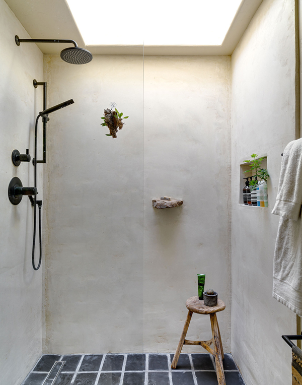 a poured concrete shower with natural elements and skylight | via coco+kelley