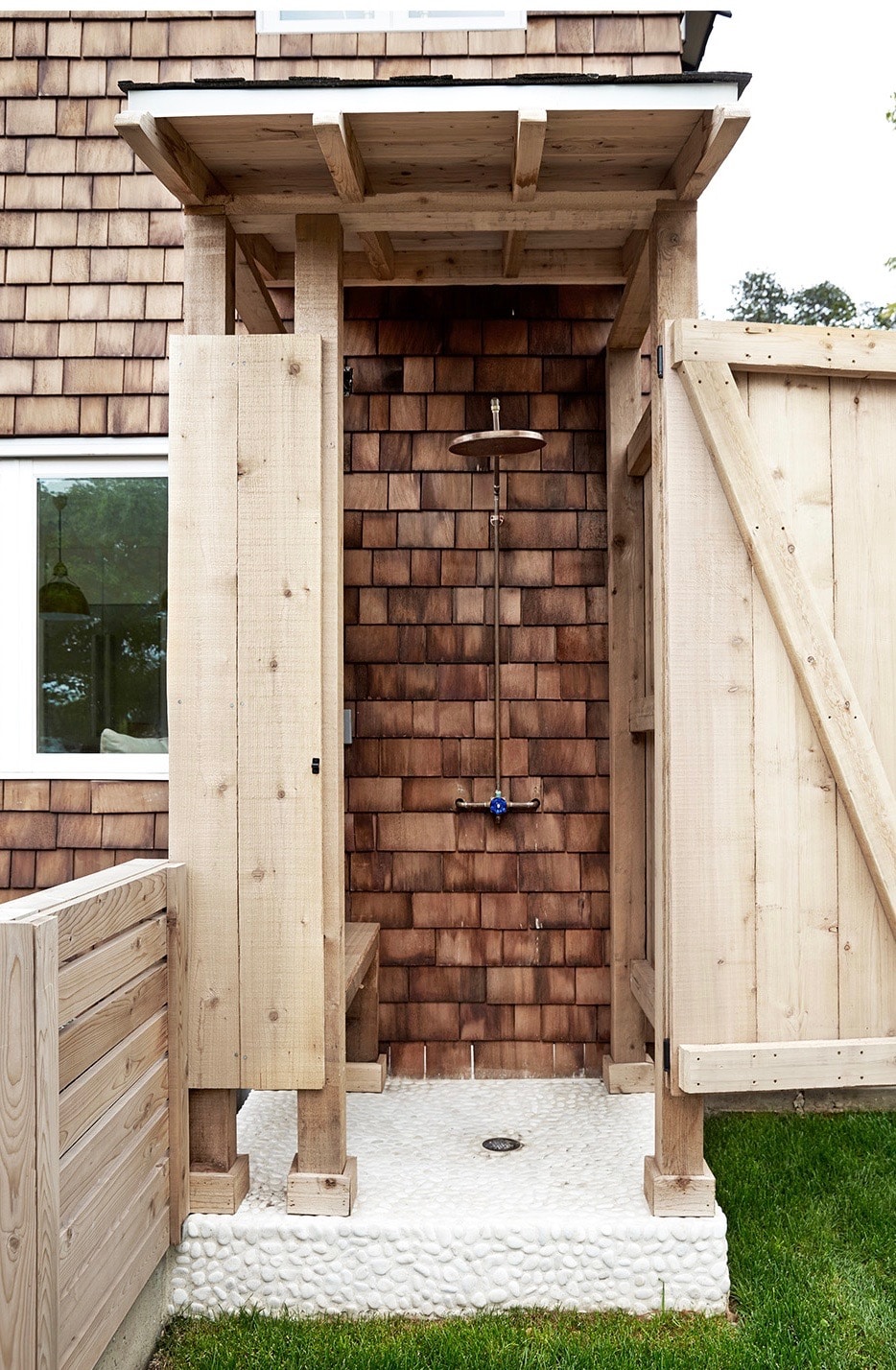 outdoor shower with shingled exterior and whitewashed stone