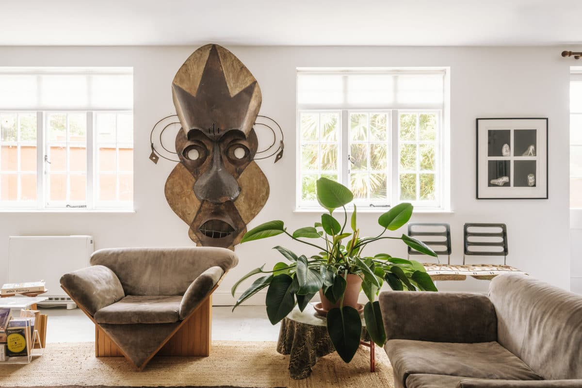 oversized african mask and 70s style furnishings in the living room - cyndia harvey london flat