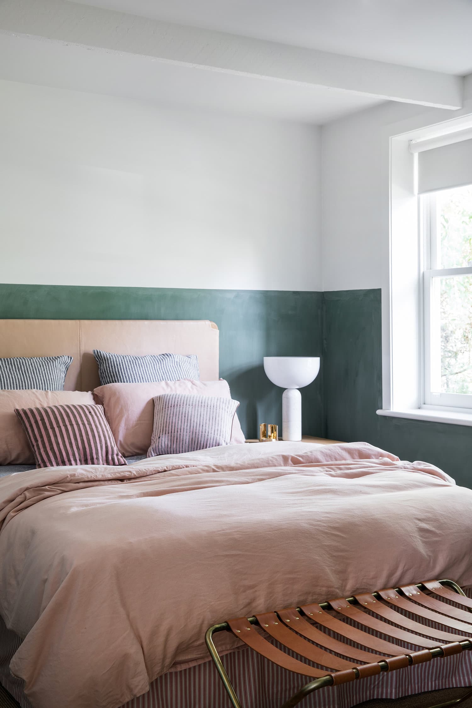 painted green half wall in main bedroom with leather headboard and linen bedding | coco kelley