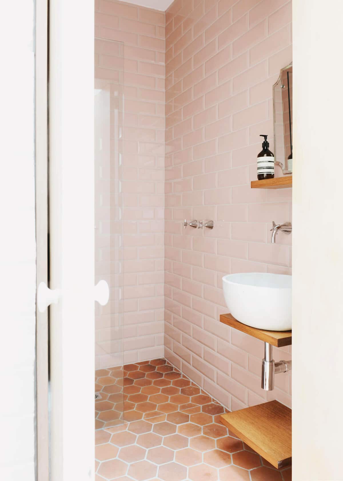 pink tiled bath with terracotta hex floors - coco kelley