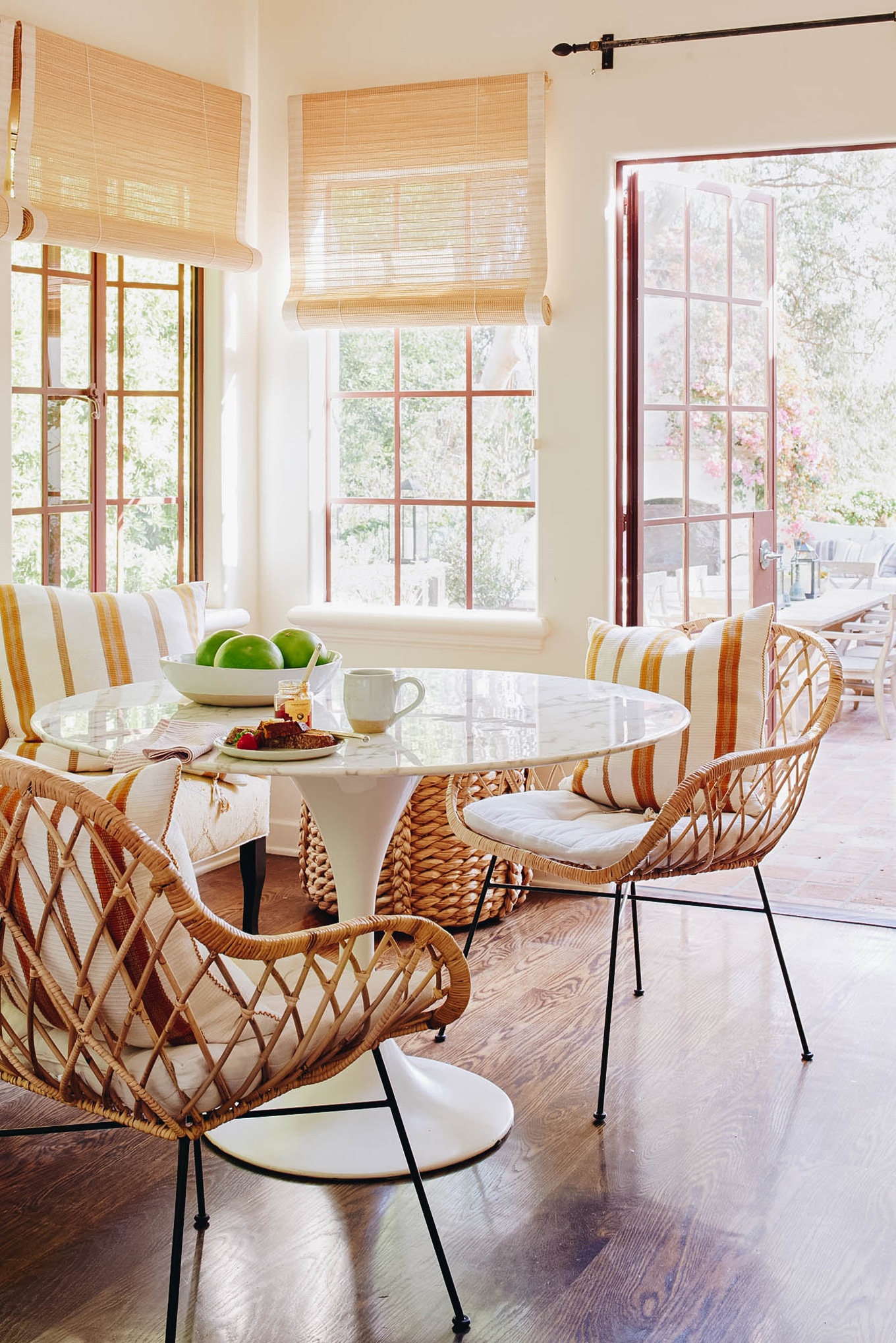 sunny breakfast nook with rattan chairs and tulip table | baja style in california house tour