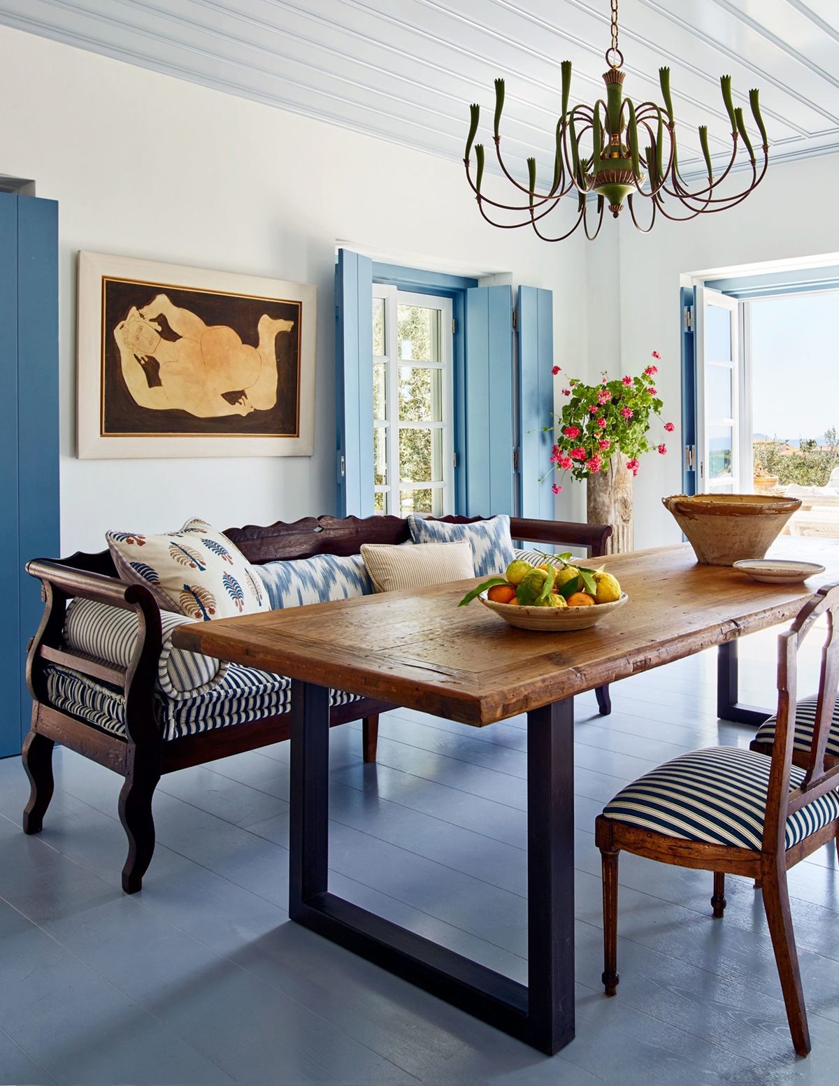 the blue and white dining room in this greek island home is balanced by warm wood antiqiues | house tour via coco kelley