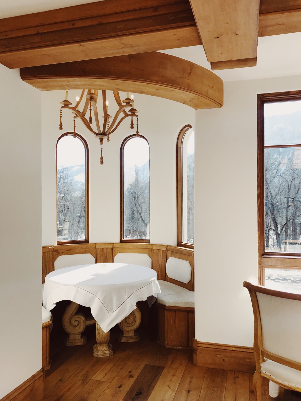 dining nook at the posthotel in leavenworth warm woods and white linens | coco kelley